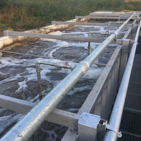 Sistema de tratamiento de agua en canal con tuberías y aireación